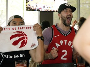 Toronto Raptors fans Sean Panganiban (left) and Brendan O'Brien (right) cheer on their team while watching game three of the NBA championship between the Toronto Raptors and the Golden State Warriors at 1st RND sports bar in Edmonton on Wednesday June 5, 2019. Raptors defeated Warriors by a score of 123-109.