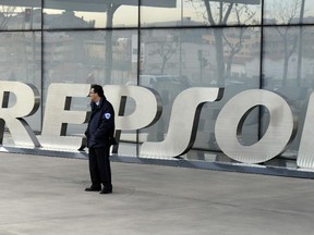 A security gaurd stands outside the main entrance to Spanish oil giant Repsol's headquarters in Madrid on January 24, 2014.