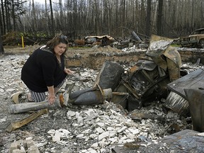 Paddle Prairie Metis Settlement resident Wilma Cardinal sifts through the remains of her sister-in-law's home on Wednesday June 19, 2019. A wildfire destroyed at least fifteen homes on the settlement, located 80 kilometres south of High Level, Alberta. All residents of the largest Metis settlement in Alberta have been evacuated but are expected to return this week.  Wildfires in northern Alberta are still burning out of control.