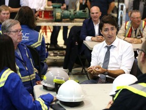 Prime Minister Justin Trudeau speaks with workers at Kinder Morgan's TransMountain pipeline terminal in Edmonton on July 12, 2019.
