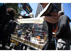 A protester holds a diorama of kids locked in a cage during a demonstration against migrant detention facilities along the U.S.-Mexico border.