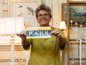 Old Strathcona Antique Mall co-owner Betty Reitan holds a signed card from the crew of Amazing Race Canada at the mall in Edmonton on Thursday, July 11, 2019. The mall was featured in an episode airing next Tuesday of the popular show.