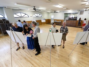 Visitors check out information boards on Monday, July 22, 2019, during a public meeting at Strathcona Community League where the City of Edmonton shared updated design and construction staging for the Scona Road/Saskatchewan Drive Intersection improvement project.