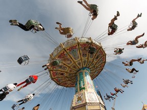 K-Days visitors ride the Wave Swinger on the midway in Edmonton, on Tuesday, July 23, 2019. Photo by Ian Kucerak/Postmedia