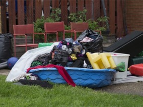 Discarded clothing and household items sit outside a home as crews work to clean up flooded homes in Edmonton's Griesbach neighbourhood, Thursday July 25, 2019. Photo by David Bloom