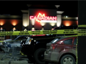 Police tape marks a perimeter around a parking lot in front of The Canadian Brewhouse on 104A Avenue in Grande Prairie, Alberta on Wednesday morning, October 1, 2014. TOM BATEMAN/DAILY HERALD-TRIBUNE/QMI AGENCY