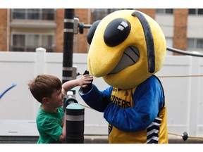 Wyatt Land, 6, plays with mascot Buzz as the Edmonton Stingers prepare meals for families at Ronald McDonald House in Edmonton on Tuesday, July 2, 2019. The house is a home-away-from-home for families with critically ill or injured children seeking medical treatment.