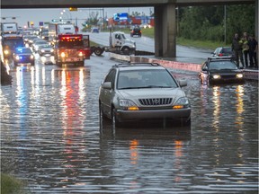 Firefighters in dry suits pushed flooded cars from the eastbound lanes of Yellowhead and about 124 Street. A sudden storm with heavy rain had just drenched the area on July 17, 2019.
