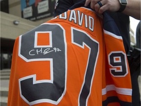 Cst. Derek Burns with the Edmonton Police Service holds a Connor McDavid jersey with a fake signature on July 18, 2019.