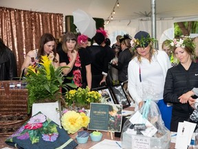 People peruse the silent auction during the Ladies on the Green garden party at Victoria Golf Course on Thursday, July 18.
