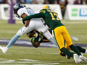 Edmonton Eskimos' Arjen Colquhoun (17) and Tyquwan Glass (19) tackle Toronto Argonauts' Derel Walker (87) during the first half of a CFL football game at Commonwealth Stadium in Edmonton, on Thursday, July 25, 2019.