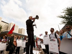 Alberta Union of Provincial Employees (AUPE) president Guy Smith speaks to members and supporters as they march from Capital Plaza near the Alberta Legislature to Jasper Ave while protesting Bill 9 in Edmonton, on Wednesday, July 31, 2019. Photo by Ian Kucerak/Postmedia