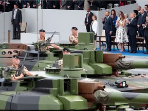 In this file photo taken on July 14, 2017, French President Emmanuel Macron, and U.S. President Donald Trump, watch members of the 5e Regiment de Cuirassiers as they participate in the annual Bastille Day military in Paris on July 14.