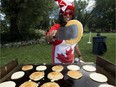Serena Hemraj flips pancakes during the Canada Day pancake breakfast, hosted by the Ismaili Council for Edmonton, at the Alberta Legislature, in Edmonton Sunday July 1, 2018. File photo.