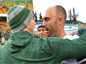 Toronto Argonauts quarterback Ricky Ray, right, gets a hug from former teammate and Edmonton Eskimos head coach Jason Maas at Commonwealth Stadium in Edmonton on Nov. 5, 2016.