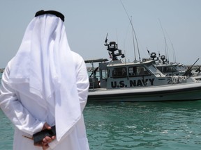An Emirati official watches members of the U.S. Navy Fifth Fleet as they prepare to escort journalists to tanker at a U.S. NAVCENT facility near the port of Fujairah, United Arab Emirates June 19, 2019.
