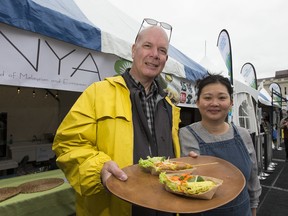 Nyonya Malaysian Cuisine owners Patrick Jacob, left, and Y.N. Lee hold their satay chicken and turmeric pancake dishes at the kick off for the 35th annual Taste of Edmonton on Thursday, July 18, 2019 in Edmonton.