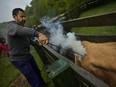 Xabi Zia Urrutia, clerk of the court of the region, brands a cow, in Sorogain, a small village in the Pyrinees mountains, northern Spain, Saturday, May 11, 2019.