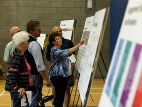 Yellowhead Trail East widening team member Mike Bindas (third from left) speaks with visitors during a public meeting at Abbotsfield Recreation Centre on the Yellowhead Trail Freeway Conversion Program in Edmonton, on Wednesday, July 17, 2019. Photo by Ian Kucerak/Postmedia