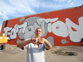 L.A. graffiti writer Slick gestures his hometown in front of his giant new mural of city, inspired in part by hockey.