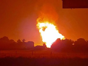 In this Thursday, Aug. 1, 2019 photo provided by Naomi Hayes, a fire burns after an explosion near Junction City, Ky. A regional gas pipeline ruptured early Thursday in Kentucky, causing a massive explosion that killed one person, hospitalized five others, destroyed railroad tracks and forced the evacuation of a nearby mobile home park, authorities said.