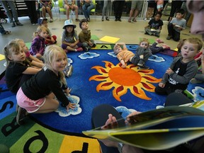 Children listen to a story as the Edmonton Eskimos football club helped kick of the Edmonton Public Library's (EPL) summer reading club at the EPL Highlands Branch on Wednesday July 4, 2018. The football club's players and cheer team members will participate in library programs across the city in July and August, to encourage children to read throughout the summer.