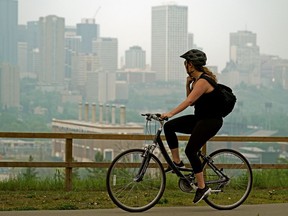 A cyclist gets a view of the smoky downtown Edmonton city skyline on Friday May 31, 2019.