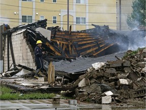 A fire investigator examines the scene of an unoccupied warehouse fire on a Fort Road lot for sale on Tuesday August 6, 2019.