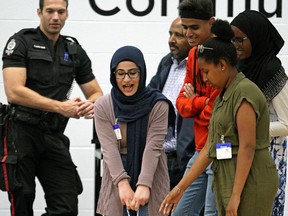 Misk Al Fadli pulls a 68 kg. mannequin for 15 metres at the Edmonton Police Service downtown headquarters on Monday, Aug. 12, 2019. She was participating in the Police and Youth Engagement Program along with other 14-17 years-old youth from the Oromo, Sudanese, Somali, Eritrean, Ethiopian, Syrian and Iraqi communities for a two-week long summer program that strives to build mutual understanding and positive relationships between youth and police.