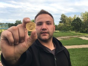 Nathaniel Williamson, 23, shows one of the many gold coins he received after finding the second installment of GoldHunt's $100,00 grand prize.