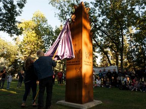 Jackie Orydzuk (left) and Kelly Roston unveil the Victims of Homicide Memorial sculpture by Edmonton sculptor Paul Toal at Borden Park on Wednesday, Aug. 28, 2019.