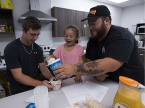 Tyler Rogers (left) works with Pablo Alvarado (right) and his daughter Gabriella Hingley- Alvardo, 5, (middle) to make an orange smoothie at the Edmonton North East Hub on Wednesday, July 31, 2019 in Edmonton.