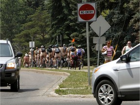 Naked bike riders head westbound on Saskatchewan Dr., as they leave the End of Steel Park in Edmonton on Saturday July 4, 2015. It was Edmonton's first Naked Bike Day, an event aimed at protesting body-shaming while pushing for reductions in car-dependency. File photo.