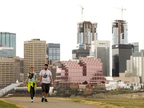 The city skyline is visible behind pedestrians as they make their way along Strathearn Crescent, in Edmonton. File photo.