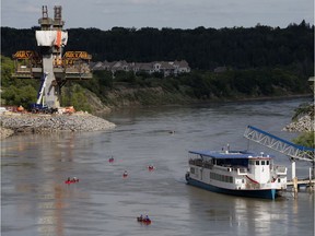 A group canoes down the North Saskatchewan River past the Edmonton Riverboat and LRT bridge construction, in Edmonton Wednesday Aug. 7, 2019. Photo by David Bloom