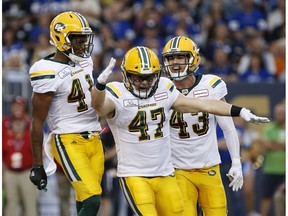 Edmonton Eskimos' JC Sherritt (47) celebrates his fumble recovery with Hunter Monshadrik (41) and Neil King (43) against the Winnipeg Blue Bombers during the first half of CFL action in Winnipeg Thursday, June 14, 2018.