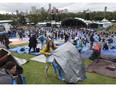 Music fans rush to set up their tarps during the second day of the Edmonton Folk Music Festival in Gallagher Park, Friday Aug. 9.