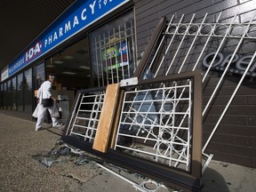 A customer walks through the damage after a SUV collided with the Millwoods IDA Pharmacy, 2841 Mill Woods Rd, in Tuesday Aug. 6, 2019.