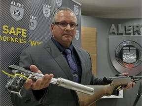 Pierre Blais, then acting inspector with ALERT, shows some of the modified guns seized at a machine shop west of Edmonton on Wednesday, Aug. 23, 2017.