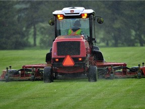 A city worker mows the grass in Hawrelak Park. File photo.