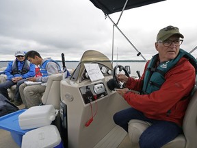 Stan Franklin, left, and Neil Flemin, volunteers from the Wabamun Watershed Management Council, assist Alberta Lake Management Society biologist Patrick Heney, middle, in taking water samples from several locations around Wabamun Lake in an effort to establish a baseline of information about the lake's water quality. This information will be used to compare with later studies in an effort to understand how the lake is changing over time as a result of climate change and development.