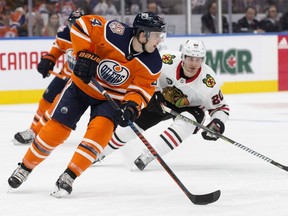 The Edmonton Oilers' Kris Russell (4) battles the Chicago Blackhawks' Brandon Saad (20) during second period NHL action at Rogers Place in Edmonton on Thursday, Nov. 1, 2018.