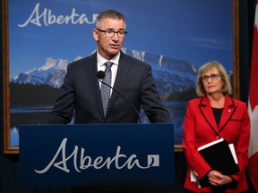 Alberta Finance Minister Travis Toews speaks about the report the province commissioned on the state of the Alberta'a finances at the McDougall Centre in Calgary on Tuesday, Sept. 3, 2019. Former Saskatchewan finance minister Janice MacKinnon who chaired the report listens in the background.