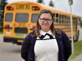 Chas Young, mother of two, poses by the bus stop her children take to go to Colonel Irvine School in Calgary on Friday, Sept. 6, 2019. With no UCP budget parents are worried about the costs of bus fees.