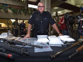 Staff Sgt. Pierre Blais shows off some of the $810,000 worth of confiscate illegal firearms and drugs from two drug trafficking investigations with dozens of charges being laid again three individuals on Sept. 9, 2019.