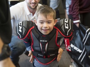 Lincoln McLean, 6,  gets his first pair of shoulder pads and can't control his excitement on September 14, 2019. Hockey Education Reaching Out Society (HEROS) is a charity that uses hockey to teach life-skills and empower marginalized youth.   They teamed up with Children's Autism Services of Edmonton to help a group of children with autism enjoy the benefits that playing hockey can bring. Photo by Shaughn Butts / Postmedia