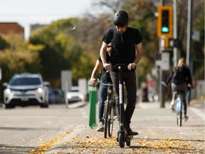 Shane Geary, a driver with Bird Canada, shows how to safely ride a Bird e-scooter along 83 Avenue in Old Strathcona during a press conference in Edmonton, on Tuesday, Sept. 17, 2019.