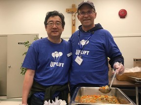 Dr. Tim Yeh, left, and Troy Davies of Catholic Social Services serve food in the basement of St. Alphonsus Parish on Saturday, Sept. 28, 2019, during the fourth annual  Uplift Day.