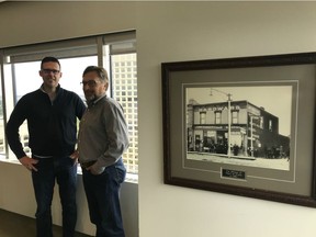Duncan Craig LLP chief operating officer Greg Miskie and managing partner Darren Bieganek pose next to a photo on Friday September 6 of the law firm's beginnings as the law office of William Short, 125 years ago.
