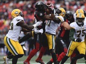 Ottawa Redblacks running back Mossis Madu Jr. (23) tries to control the ball against Edmonton Eskimos linebacker Larry Dean (11) during first half CFL football action in Ottawa on Saturday, Sept. 28, 2019.